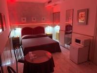 a red room with a bed and a table in it at Hotel Malpensafiera in Bernate Ticino