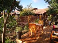 a wooden deck with two chairs and a table at la cabane vensac ocean montalivet in Vensac