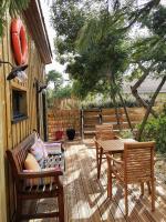 a patio with two chairs and a bench and a table at la cabane vensac ocean montalivet in Vensac