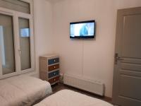 a bedroom with a bed and a tv on the wall at La Tanatte de wimereux sur la côte d opale in Wimereux