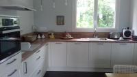 a kitchen with white cabinets and a sink and a window at chez sylvette in Quinsac