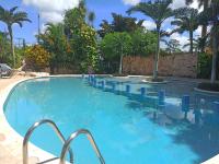 a large swimming pool with blue chairs and palm trees at Ecotel Quinta Regia in Valladolid