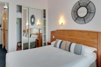 a hotel room with a bed and a mirror at Brit Hotel Europ Bergerac in Bergerac