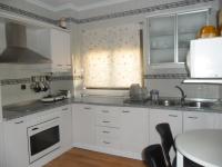 a kitchen with white cabinets and a table at Casa Las Lomas in Prado del Rey