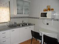 a kitchen with a sink and a microwave at Casa Las Lomas in Prado del Rey