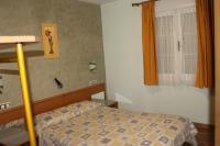 A bed or beds in a room at Hostal Burbia