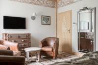 a living room with a chair and a television at Aries Hotel & SPA Wisła in Wisła