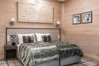 a bedroom with a bed with a wooden wall at Aries Hotel & SPA Wisła in Wisła
