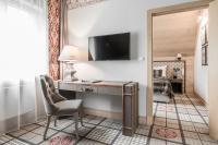 a room with a desk with a television and a bed at Aries Hotel & SPA Wisła in Wisła