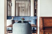 a dining room with chairs and a table with a vase of flowers at Hotel Dermuth Klagenfurt in Klagenfurt