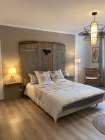a bedroom with a large bed with a wooden headboard at Au P’Tit Cosy in Bazincourt-sur-Saulx