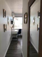 a hallway with a table and a chair and a mirror at Logis Hôtel l&#39;Abricotine in Tain-lʼHermitage