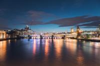 a bridge over a river with a city at night at citizenM Southwark Bankside in London