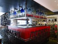 a red bar with bar stools in a restaurant at citizenM Southwark Bankside in London