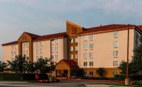 un edificio de hotel con un cartel en el costado en Red Roof PLUS Long Island - Garden City, en Westbury
