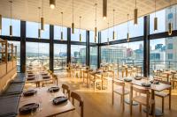 Un restaurante con mesas y sillas y grandes ventanales. en Crowne Plaza Adelaide by IHG, en Adelaida