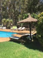 a pool with a straw umbrella and lounge chairs and a swimming pool at Molino El Mastral in Tarifa