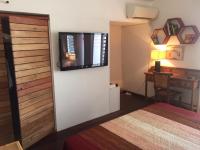 a bedroom with a bed and a television on the wall at BAY VIEW MARTINIQUE in Les Anses-dʼArlets