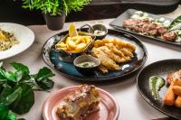 a table topped with plates of food and french fries at Timeout Heritage Hotel Zagreb in Zagreb