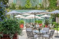 a patio with tables and chairs and umbrellas at Le Bristol Paris - an Oetker Collection Hotel in Paris