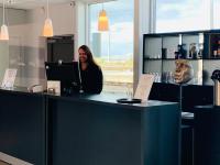 Una mujer parada detrás de un mostrador con una computadora portátil. en P-Hotels Brattøra, en Trondheim