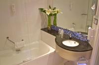 a bathroom with a sink and a tub with a vase of flowers at Holiday Inn Express Campo de Gibraltar-Barrios, an IHG Hotel in Los Barrios