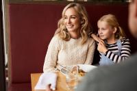 een vrouw en een klein meisje zitten aan een tafel eten bij RACV Inverloch Resort in Inverloch