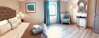 a bedroom with a bed and a chair and a mirror at La Bri...Gite in L&#39;Isle-sur-la-Sorgue