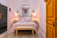 a bedroom with a bed and two lamps on two tables at Cortijo El Indiviso in Vejer de la Frontera