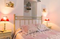 a bedroom with a bed with two tables and two lamps at Cortijo El Indiviso in Vejer de la Frontera