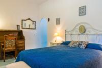a bedroom with a blue bed and a dresser at Cortijo El Indiviso in Vejer de la Frontera