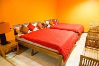 two beds in a room with orange walls at Golden Ocean Azure Hotel in Kenting