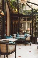 a patio with a couch and tables and chairs at Hôtel de l&#39;Abbaye in Paris