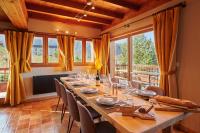 a dining room with a long table with chairs and windows at Chalet ALPACA Peisey-Vallandry - Domaine Paradiski in Peisey-Nancroix