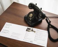 a telephone sitting on a table next to a paper at AMERON Hamburg Hotel Speicherstadt in Hamburg