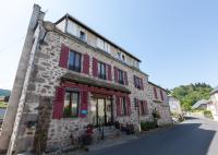 - un vieux bâtiment en pierre avec des volets rouges dans une rue dans l&#39;établissement La Belle Arverne, à Albepierre-Bredons