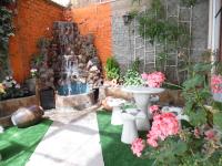 a garden with a fountain and some pink flowers at Hotel Puno Terra in Puno