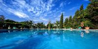 a large swimming pool with blue water and trees at Hotel Punta Sur in Tarifa