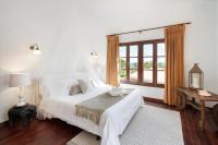 a white bedroom with a large bed and a window at Hotel Punta Sur in Tarifa