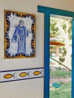 a painting of a man on a wall next to a window at Pousada São Francisco in Cumuruxatiba