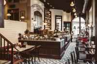 um restaurante com mesas, cadeiras e um bar em The Vault Hotel, WorldHotels Crafted em Helsingborg