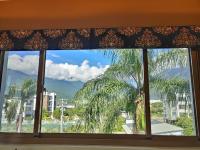 a window with a view of a palm tree at White Palace B&amp;B in Ji&#39;an