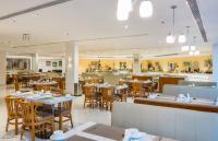 Un comedor con mesas y sillas en un restaurante. en Alreem Village Hotel, en Al Jubail