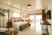 a bedroom with a bed and a living room at Pousada Casa do Catavento in Búzios