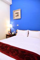 a bedroom with a large bed with a blue wall at Plentiful-Inn Kenting in Hengchun South Gate