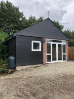 einen schwarzen Schuppen mit Tür und Fenster in der Unterkunft Our Wendy House in Holsworthy
