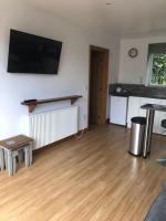 ein Wohnzimmer mit Holzböden und einem Flachbildfernseher in der Unterkunft Our Wendy House in Holsworthy