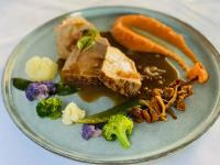 a plate of food with meat broccoli and vegetables at Domaine de Suzel Hôtel & Spa in Vignieu