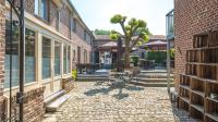 a courtyard with a brick building and a tree at Hoeve de Sterappel in Tongeren