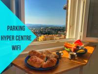 a table with a plate of bread and a bowl of fruit at Parking Privé - Vue mer - WiFi - Centre Historique in Grasse